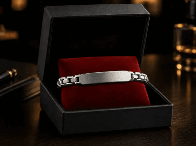 Silver engravable bracelet presented in a black gift box on a red velvet cushion